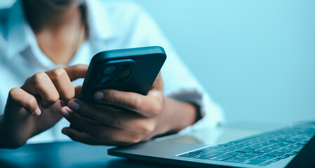 Person Using Smartphone and Laptop for Online Communication and Mobile Work