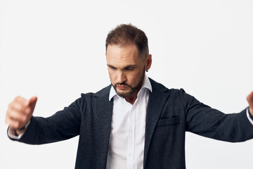 A business professional man stands with arms outstretched against an isolated colored background,...