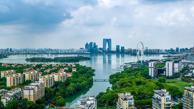 Aerial view of the modern city skyline and residential district alongside a large lake in Suzhou.