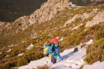 Mother and son climbing a mountain, walking across a snowfield