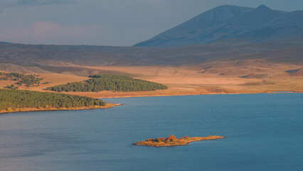 Vast Mountain Lake with Forested Islands and Golden Hills