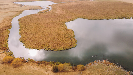 Aerial View of a Winding River Through Dry Golden Grasslands