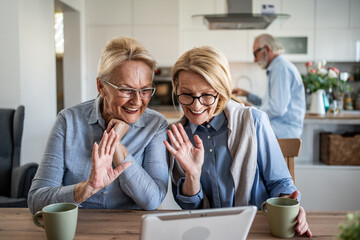 Senior women video calling family and friends on tablet