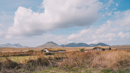Rustic Grass-Roofed House in a Vast Mountain Landscape