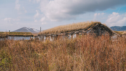 Rustic Grass-Roofed House in a Vast Mountain Landscape