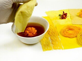 Dyeing a sample of cotton fabric in marigold flowers broth, DIY. 