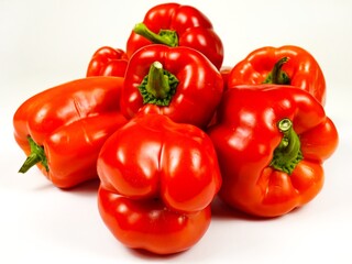 Heap of fresh red bell peppers are on a white board