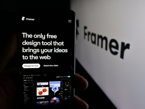 Stuttgart, Germany - 10-27-2025: Person holding cellphone with webpage of Dutch design platform company Framer B.V. on screen in front of logo. Focus on center of phone display.
