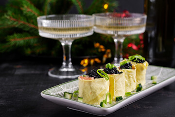 Canapes appetizer with salmon and black caviar on the Christmas table. Canapes with fish and caviar.