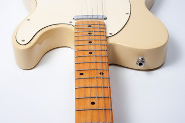 Six-string electric guitar, with a cream-colored wooden body and chrome-plated fittings.