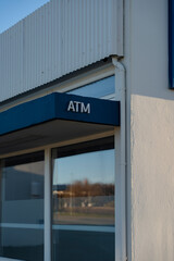 Obraz premium Facade of a building featuring an ATM sign above the windows. Blue and white.