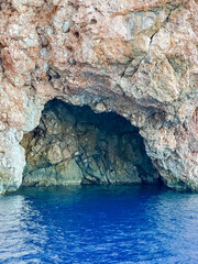 Blue sea cave entrance in white limestone cliff with turquoise Mediterranean waters near Antalya, Turkey. High quality photograph