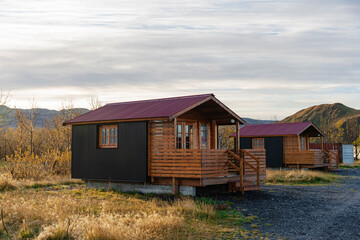 Obraz premium Scenic cabins with rusty red roofs nestled in a serene landscape.