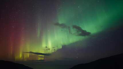 Breathtaking Aurora Borealis display painting the tranquil night sky with vibrant green and reddish-purple light, a mesmerizing natural phenomenon over a serene landscape