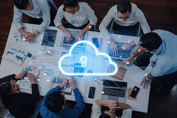 A diverse team collaborates on cloud security solutions within a modern office setting, utilizing laptops and engaging in innovative data sharing and discussions. Trope