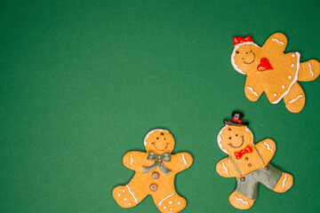Hand-decorated gingerbread family cookies on green background