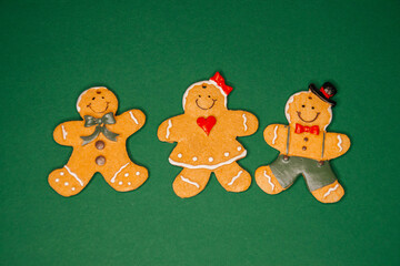 Hand-decorated gingerbread family cookies on green background