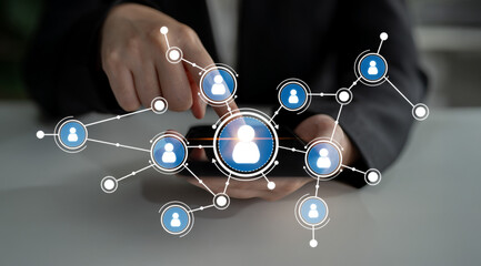 A business professional engages with a smartphone displaying a digital network of user profiles, highlighting modern connections in a professional workspace. Crux
