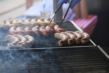 Grilling sausages on the grill with flames and smoke. food tasty sausadges, Sausage grilled to perfection on Barbeque.
