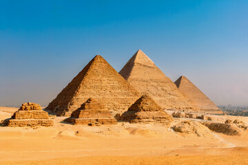 A Daytime Photograph of the Great Pyramids of Giza in the Egyptian Desert under a Clear Blue Sky