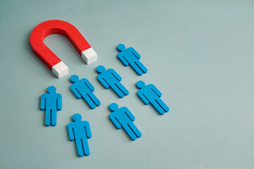 A Minimalist Business Concept Image Showing a Red Magnet Attracting a Group of Blue Person Figures