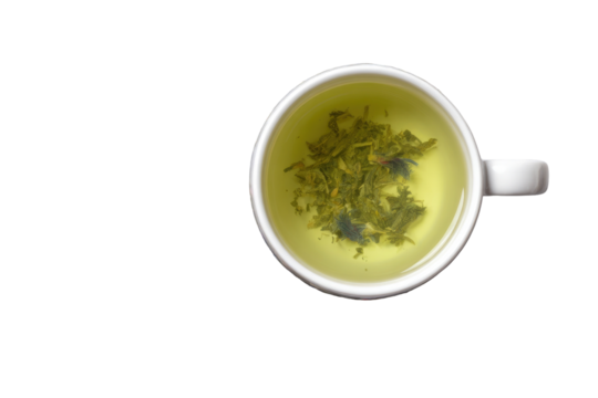 Overhead view of a cup of light green tea.  Small pieces of tea leaves and possible floral additions float in the liquid.  White ceramic cup