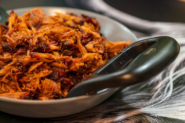 Pulled pork home made prepared in kitchen with fork in close up view