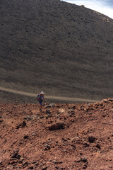 Fototapeta premium Woman hiking on volcanic slope
