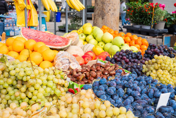 Sweet fruits and berries, grapes and plums, assortment on the counter at the market