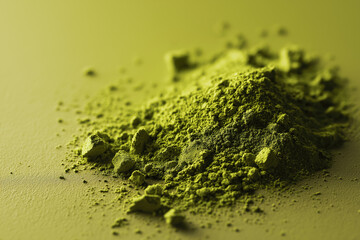 Green powder heap on textured surface with soft lighting  
