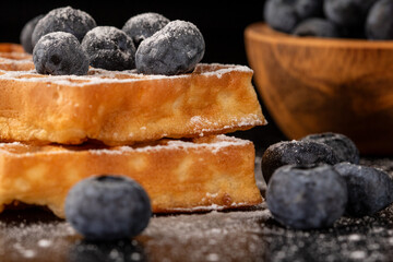 Mouthwatering belgian waffles with blueberries and powdered sugar
