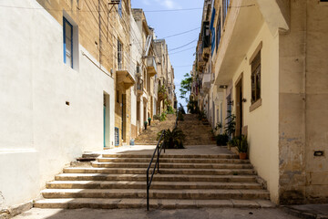 A pathway made of stairs between limestone buildings in Isla, Malta