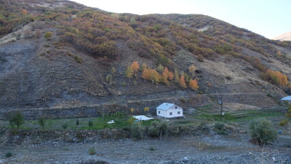 A chalet at the foot of the mountains in autumn.