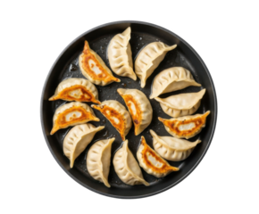 A top view of a pan filled with several dumplings some cut in half showing the filling