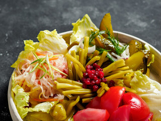Assorted snacks from fermented cabbage, cucumbers and tomatoes, green bean. Decorated cranberry. Fermented healthy food concept. Pickled cucumbers, marinated tomatoes. Close up