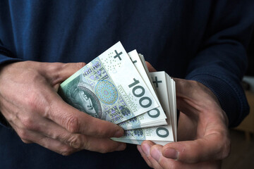 Savings in a man's hand, Polish zlotys.
