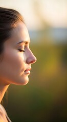 Serene woman in profile, eyes closed, bathed in golden light.