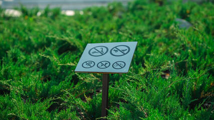 Prohibition sign standing on green grass in the park