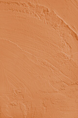 Close up, macro of vibrant orange colored cement wall surface with rough, heavily textured, and abstract plaster strokes. Grunge background, industrial backdrop, modern wallpaper, design element.