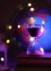 The hourglass sand glass as symbol of passing time and the globe travel photo geography festive...
