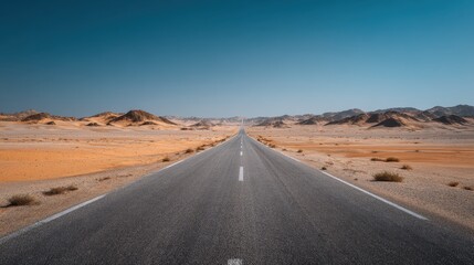A straight desert highway with clear asphalt markings, sand dunes on the sides, and a bright, expansive sky.