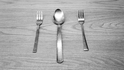 Spoon between two forks in a black and white image for editorial use