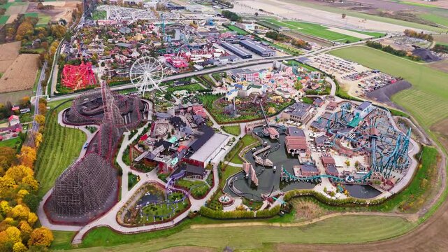 Aerial drone view of Energylandia amusement park in Zator, Poland. Colorful rides, roller-coasters and crowds under sunny weather, high-energy entertainment hub.