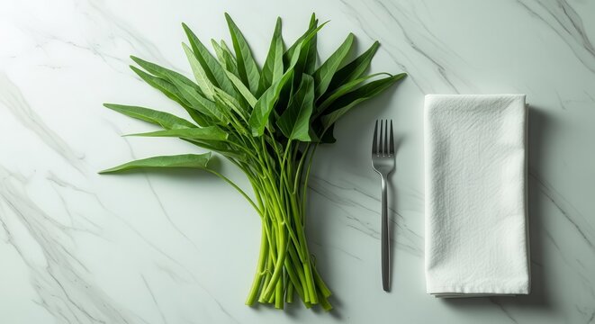 Fresh And Natural Greens, With Cutlery And A Napkin, Laying On A Marble Surface
