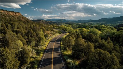 Obraz premium Open road through green landscape with hills in the distance, creating a serene and creative outdoor scene.