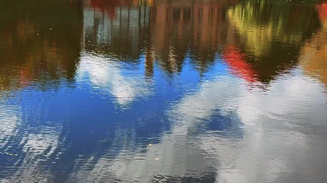 The lake landscape and the reflection of nature and trees on the water.
Small waves on the lake in a warm, windless day.