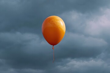 A lone orange balloon floats against a dramatic stormy sky