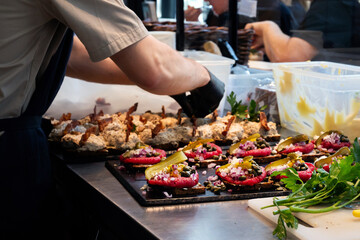 A chef's hand making open Danish sandwiches with ground beef, tartare smorrebrod.