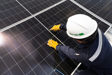 Engineer checking inspection solar cells on the roof.Technician maintaining solar panels on blue sky and white clouds background.Solar photovoltaic panel system and saving energy with clean powers.