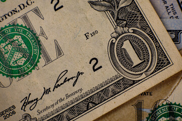 Close-up view of United States one dollar bill alongside other currency, highlighting intricate design and historical details in Washington D.C